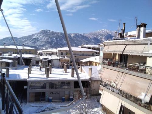 a view of a snow covered building with mountains in the background at Διαμέρισμα Μαρία in Kalabaka