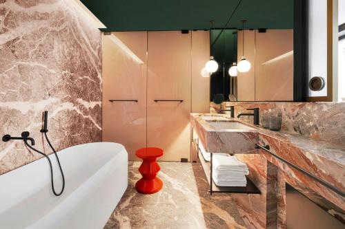 a bathroom with a bath tub and a sink at Casa Brera, a Luxury Collection Hotel, Milan in Milan