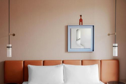 a bed with two pillows and a picture on the wall at Casa Brera, a Luxury Collection Hotel, Milan in Milan