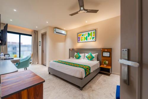 a bedroom with a bed and a desk in a room at Treebo Raahgir Suites in Noida