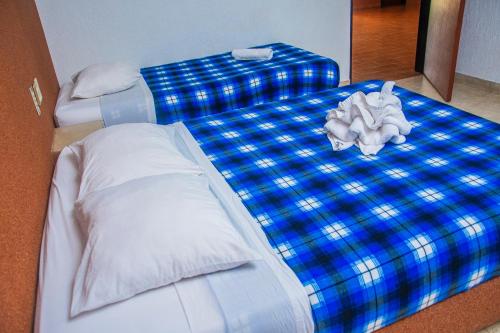 a blue and white bed with a stuffed animal on it at Hotel Espor CA in Barinas