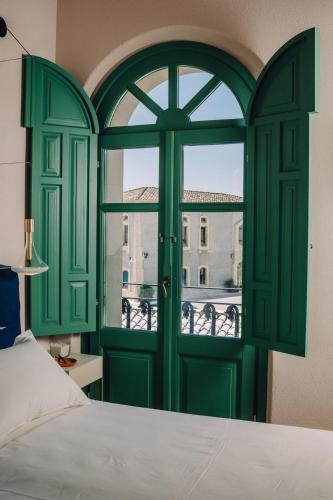 a bedroom with a green door and a window at Casa di Nonno in Serdiana