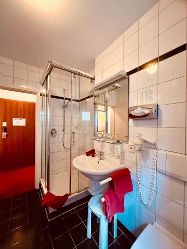 a bathroom with a sink and a shower at Hotel Weisses Lamm in Veitshöchheim