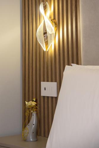 a bedroom with a bed and a light switch at The Three Diamonds - B&B CESENATICO in Cesenatico