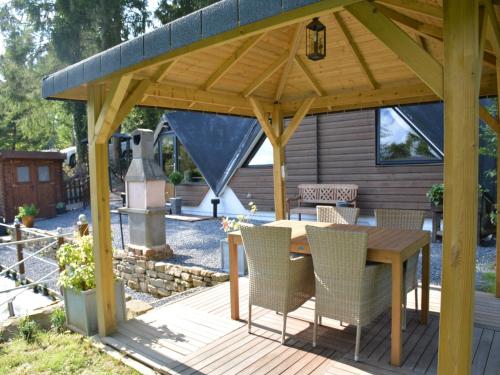 a wooden pavilion with a table and chairs on a deck at Chalet in Gesves with Roof Terrace, Garden, BBQ in Gesves