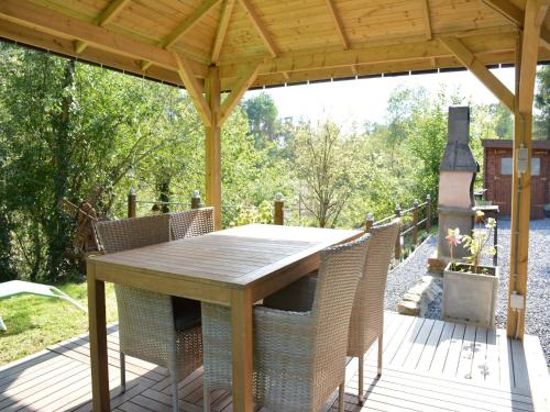 a wooden deck with a wooden table and chairs at Chalet in Gesves with Roof Terrace, Garden, BBQ in Gesves