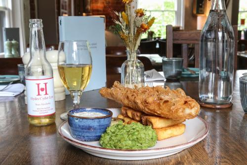 a plate of food on a table with a glass of wine at The Hideaway at Hoddington Arms in Upton Grey