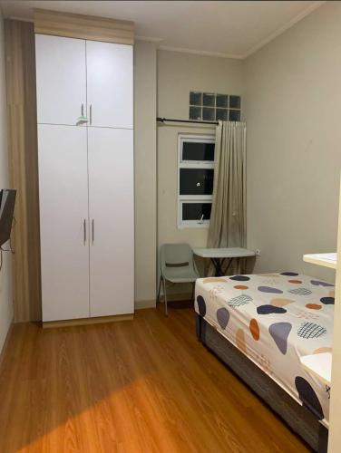a bedroom with a bed and a cabinet and a desk at PH Residence Jakarta - Gajahmada in Jakarta
