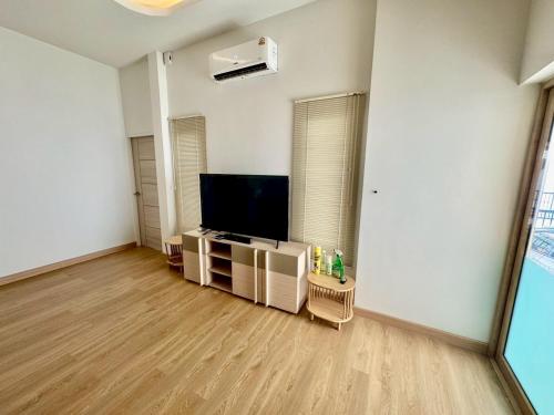 ein leeres Wohnzimmer mit einem Flachbildfernseher in der Unterkunft Minimalist Haven in Ban Mai I