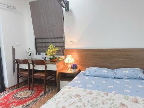 a bedroom with a bed and a table and a desk at Trăng Khuyết 404MD in Hanoi