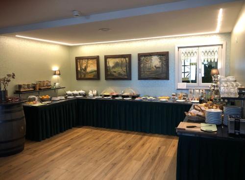 a restaurant with a counter with food on it at Akzent Berghotel Rosstrappe in Thale