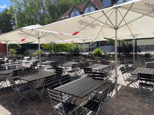 a group of tables and chairs with white umbrellas at Akzent Berghotel Rosstrappe in Thale