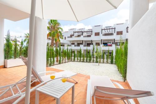 a balcony with a table and chairs and a building at Modern 2BR Apt with own Terrace & Pool access in Pulpí