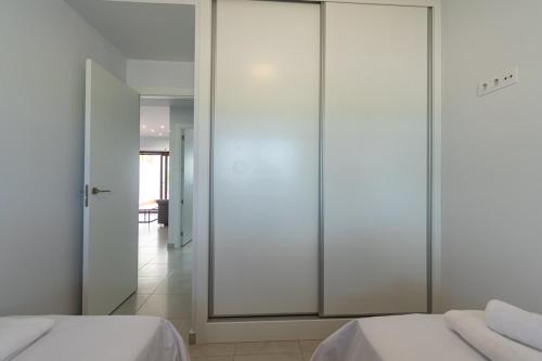 a bedroom with white walls and sliding glass doors at Modern 2BR Apt with own Terrace & Pool access in Pulpí