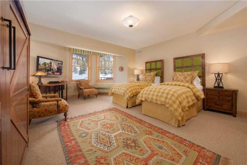 a large bedroom with two beds and a table and chairs at RMR: Cody House B Condo in Teton Village in Teton Village