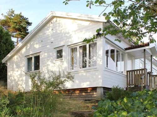 a small white house in a field with trees at 4 person holiday home in UDDEVALLA-By Traum in Sundsandvik