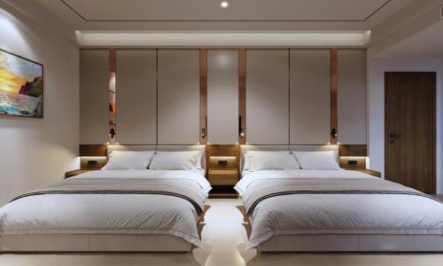 a bedroom with two beds and a headboard at Royal Hotel in Móng Cái