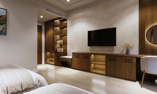 a bedroom with a bed and a flat screen tv at Royal Hotel in Móng Cái