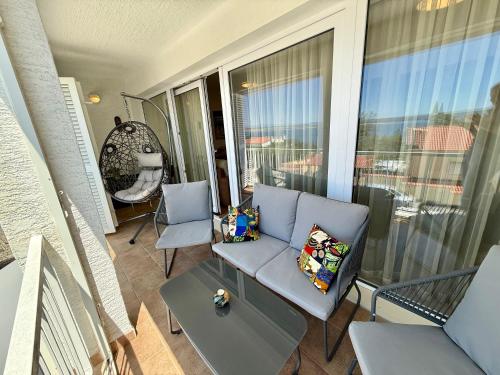 a balcony with a couch and chairs on a balcony at Apartman Val in Dramalj