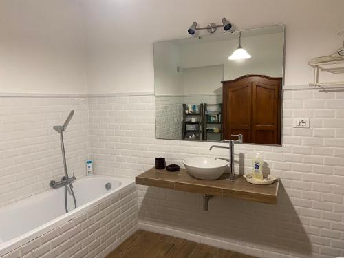 a bathroom with a sink and a tub and a mirror at Villa Silvana Quiet Escape in Bolsena