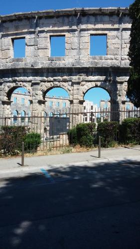 a stone building with three arched windows on it at Arco Arina Apartment in Pula