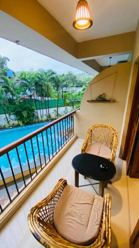 a balcony with a rattan chair and a bench at Ashvem Beach inn in Mandrem