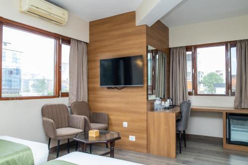 a hotel room with a tv on a wall at Hotel Marcopolo in Kathmandu