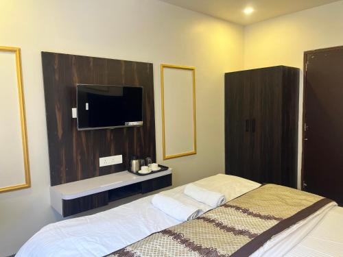 a bedroom with a bed and a flat screen tv at Jeel Pearl Hotel in Udaipur