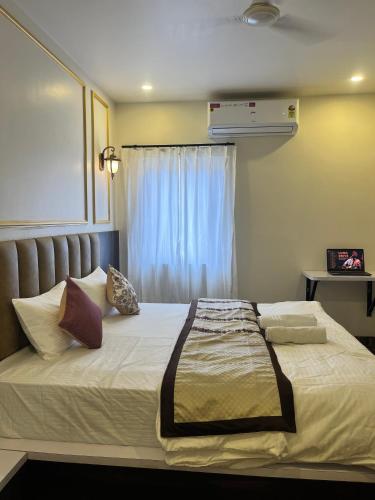 a bedroom with a large white bed with a window at Jeel Pearl Hotel in Udaipur