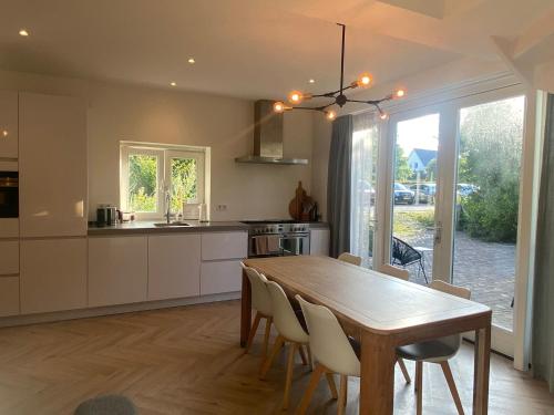 a kitchen and dining room with a wooden table and chairs at Ons Huisje Achter in Noordwijkerhout