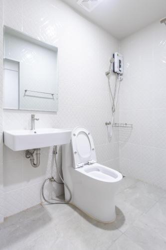 a white bathroom with a toilet and a sink at WJ Luxury Sathorn in Bangkok