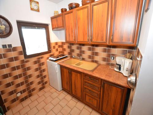 a small kitchen with wooden cabinets and a sink at Chalet in Malá Skála near Ski Slopes in Malá Skála
