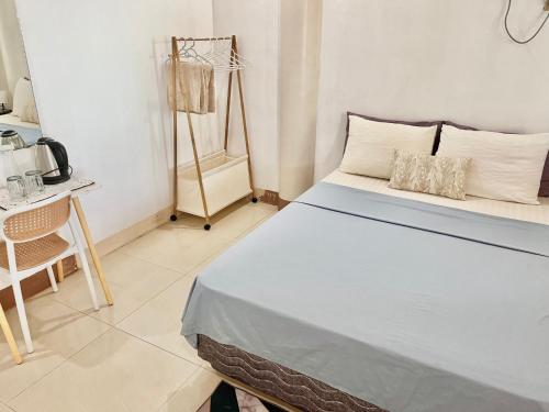 a bedroom with a bed and a table and a chair at Casaroyal Beachfront Siquijor in Siquijor
