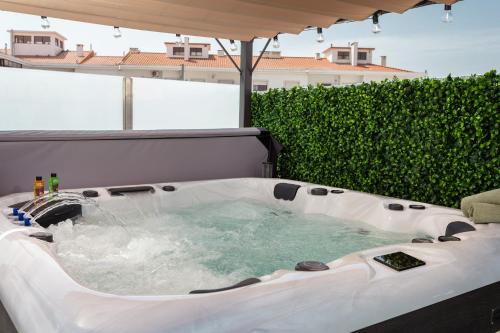 a jacuzzi tub on top of a patio at Linda s Guest House Alojamento 2 in Costa da Caparica