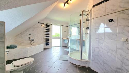 a bathroom with a shower and a toilet and a tub at Ferienhaus Engelhardt in Ebergötzen