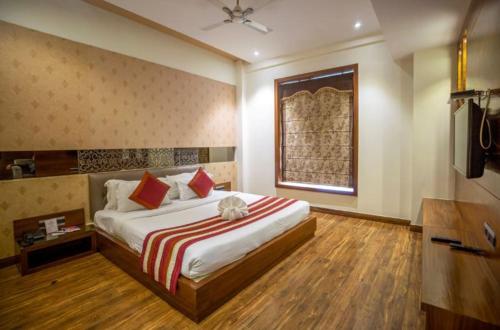 Un dormitorio con una cama y un televisor. en hotel the royal bharti, en Vrindāvan