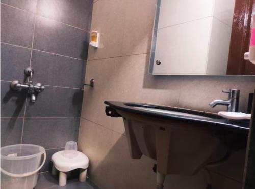 a bathroom with a sink and a toilet and a mirror at Hotel Orient Crown, Kolhapur in Kolhapur
