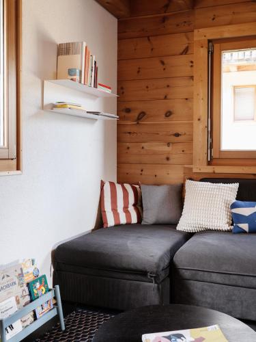 a living room with a couch and a window at Chalet mit Sauna an der Piste in Rosswald
