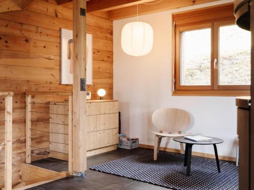 a room with wooden walls and a table and a chair at Chalet mit Sauna an der Piste in Rosswald
