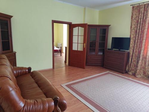a living room with a leather couch and a television at VerhHouse in Yaremche