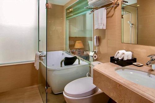 Un baño con inodoro, lavabo y bañera. en Hanoi Paon Hotel & Spa, en Hanói