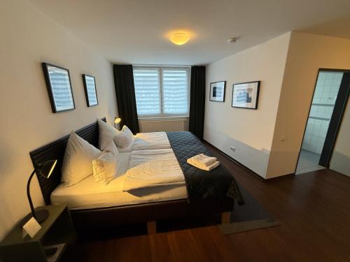 a bedroom with a bed with white sheets and a window at Hotel NeuHaus in Dortmund