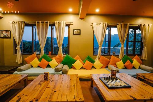 a living room with a couch with colorful pillows at Zostel Pokhara in Pokhara