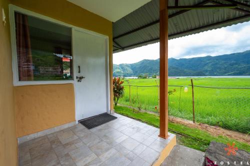 a porch of a house with a view of a field at Zostel Pokhara in Pokhara