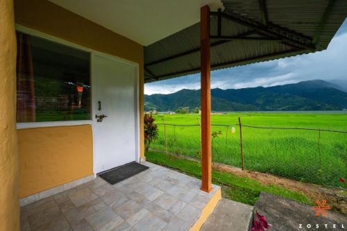 a porch of a house with a view of a field at Zostel Pokhara in Pokhara
