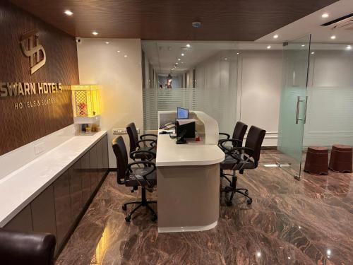 an office with a desk with chairs and a computer at Swarn Hotel in Kolkata