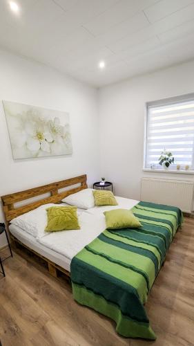 a bedroom with two beds with green and white pillows at Ferienhaus Marcali - Erholung am Thermalbad und Plattensee in Marcali