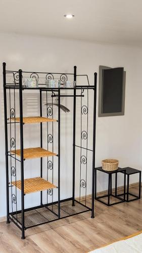 a black shelf with bowls on it next to a table at Ferienhaus Marcali - Erholung am Thermalbad und Plattensee in Marcali