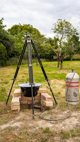 a tripod with a bowl and a bucket in a field at Ferienhaus Marcali - Erholung am Thermalbad und Plattensee in Marcali