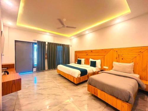 a hotel room with two beds and a tv at The Edge Retreat A Premium Property in Mussoorie